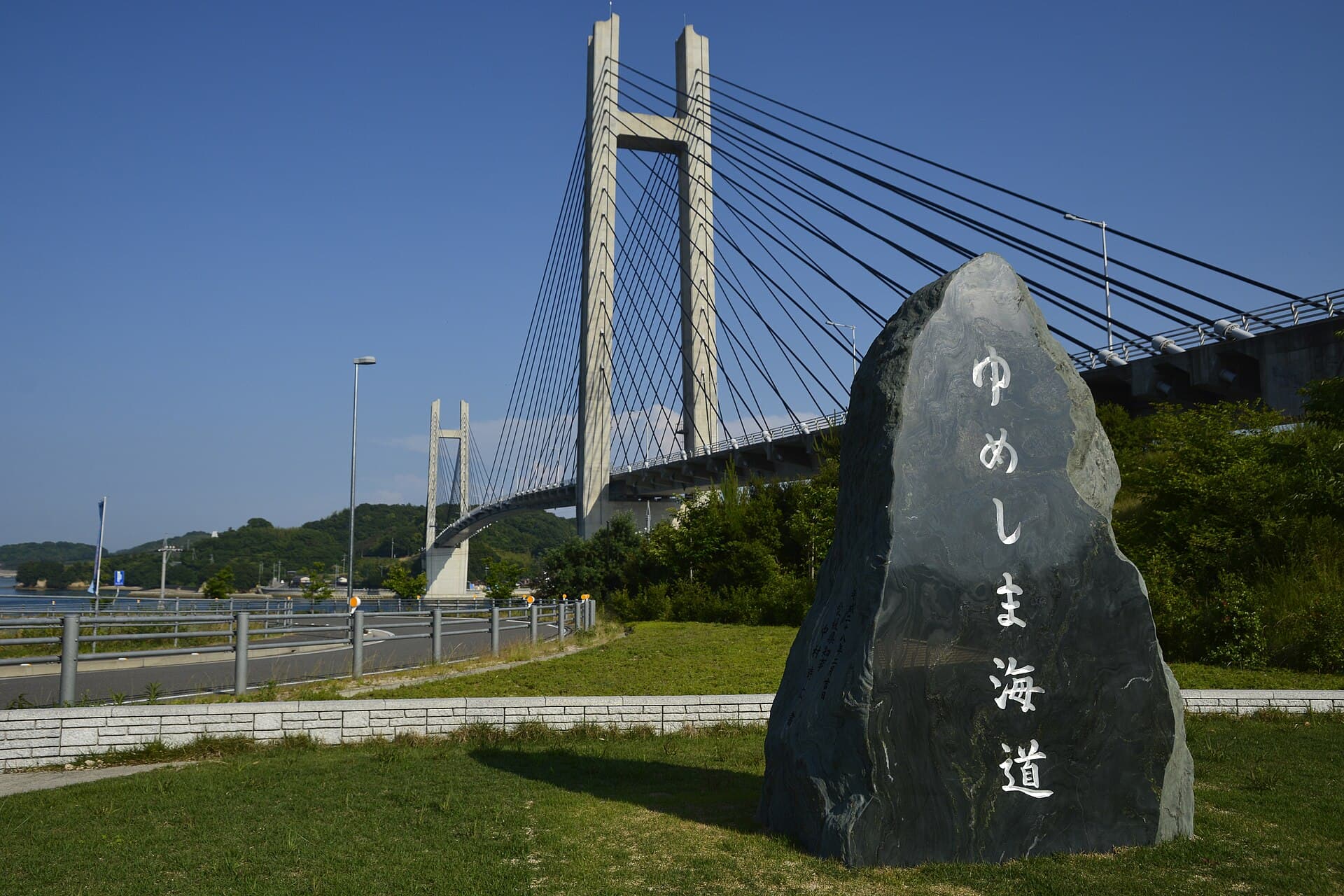 生名桥：生名橋：纪念石碑、桥塔与岛屿道路环境。