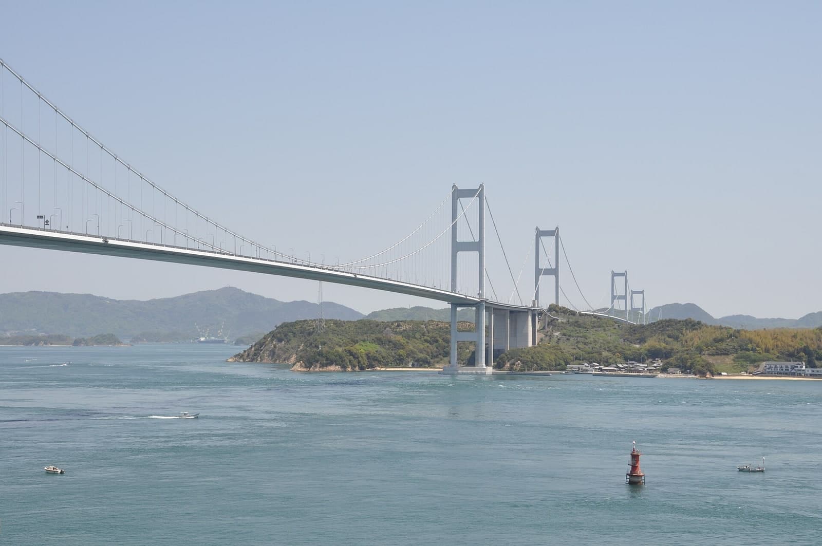 来岛海峡大桥群：从爱媛一侧拍摄的桥塔、主缆和海峡实景；文件说明直接指向 Imabari—Yoshiumi 的来岛海峡大桥。