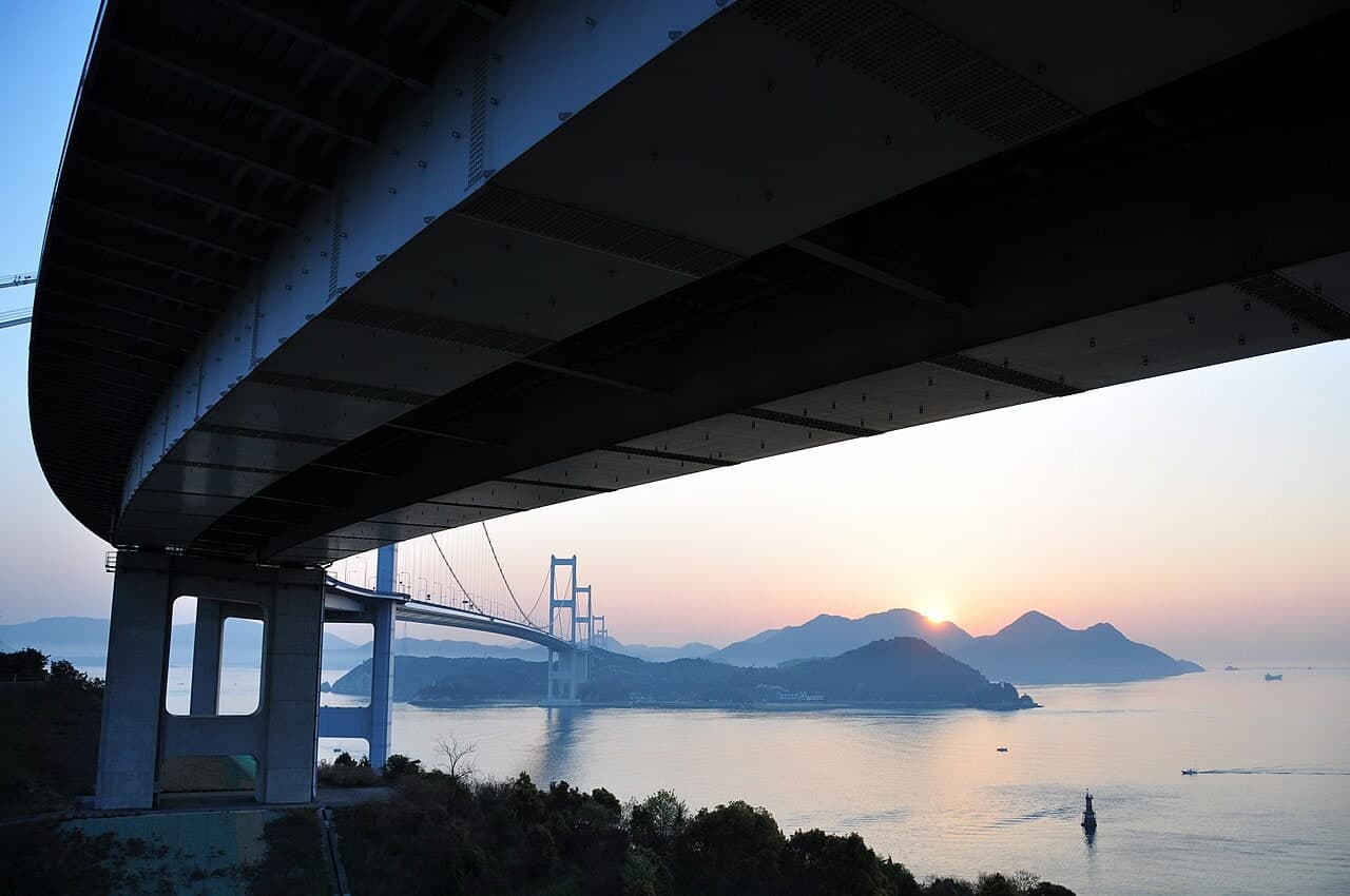 来岛海峡大桥群：夕照条件下的来岛海峡大桥主缆、桥塔和海峡轮廓。