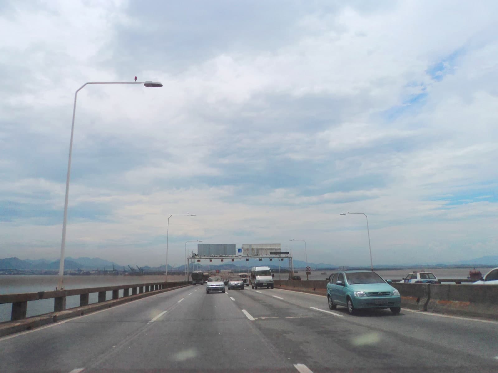 里约—尼泰罗伊大桥：桥面行车视角，主体为道路交通、护栏和桥上运行状态。