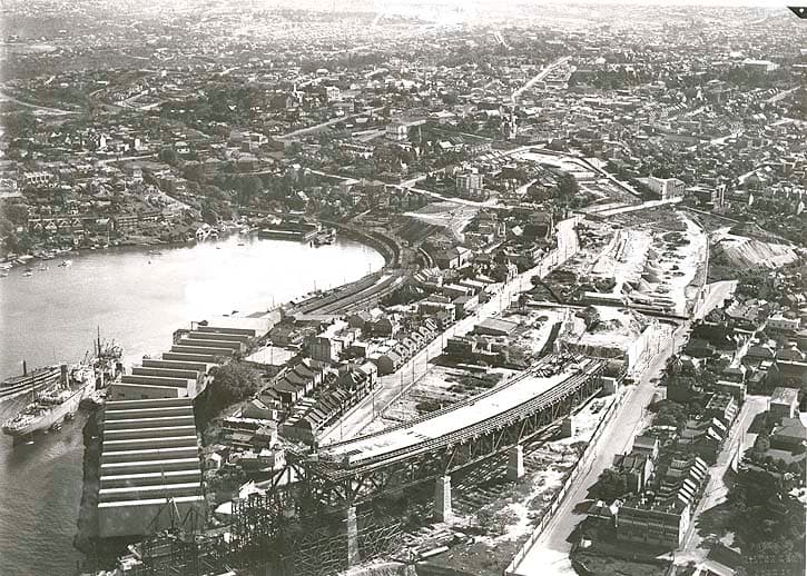 悉尼海港大桥：约 1920 年北岸航拍：可见北岸铁路旧线位与跨桥改线、延伸工程。