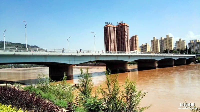 七里河黄河大桥：七里河黄河大桥近景，连续桥面、重力式桥墩和城市岸线清晰。